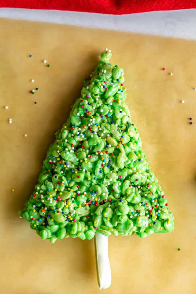 Christmas tree made of Rice Krispies cereal and decorated with sprinkles and a pretzel stem