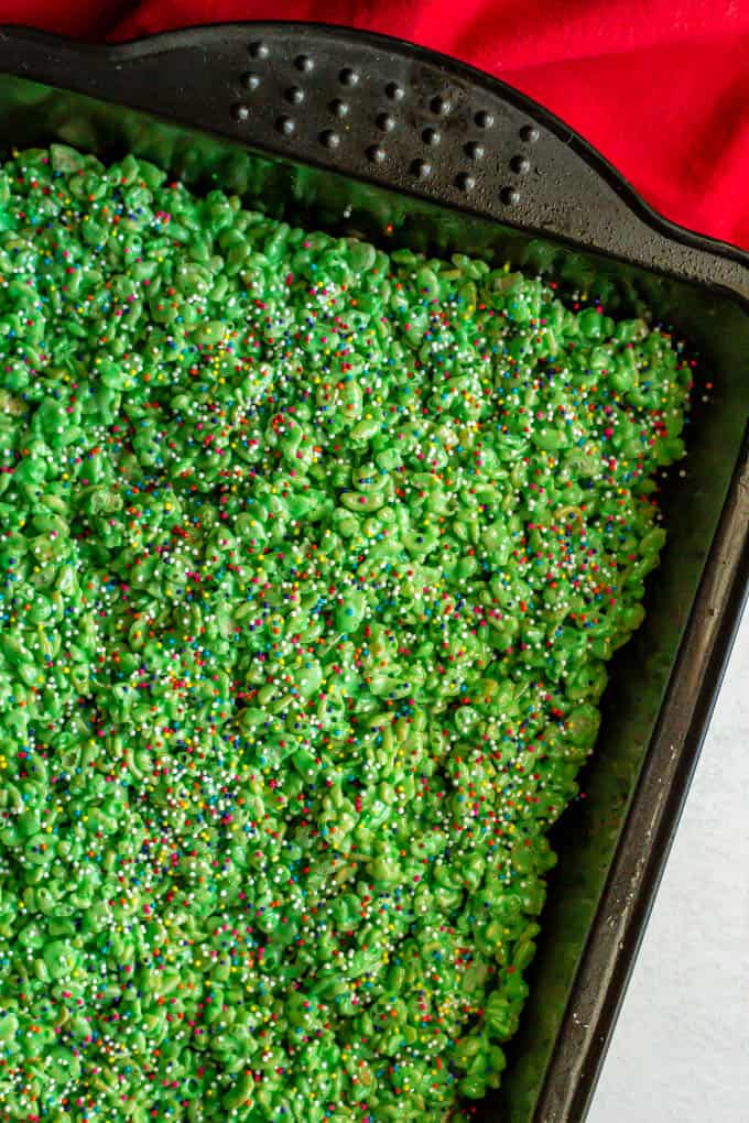 Close up of green colored crispy rice treats setting up in a pan