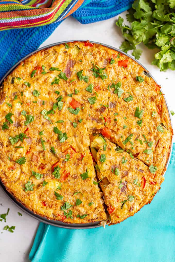 A round baked egg frittata with chicken and vegetables topped with chopped cilantro