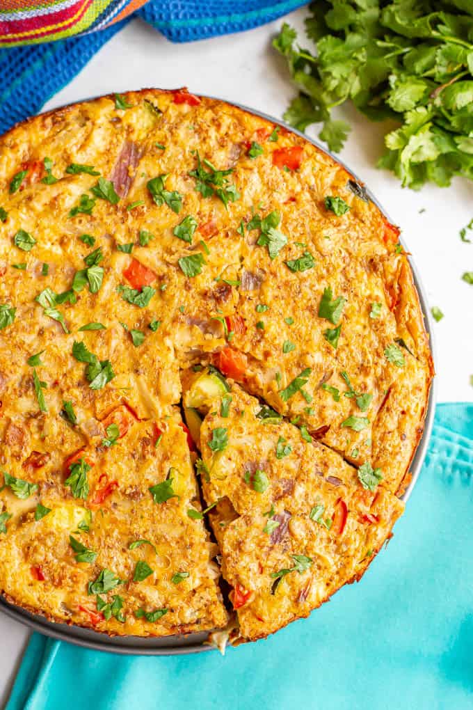 A baked chicken vegetable frittata with a slice cut on one side