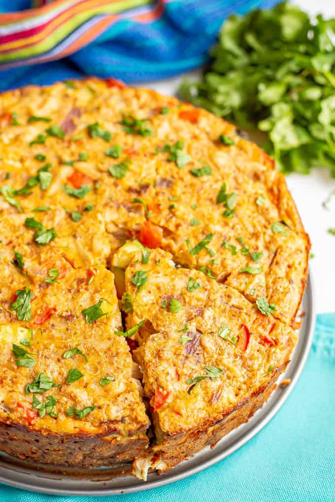 A slice of southwestern baked frittata with chicken and vegetables topped with chopped cilantro