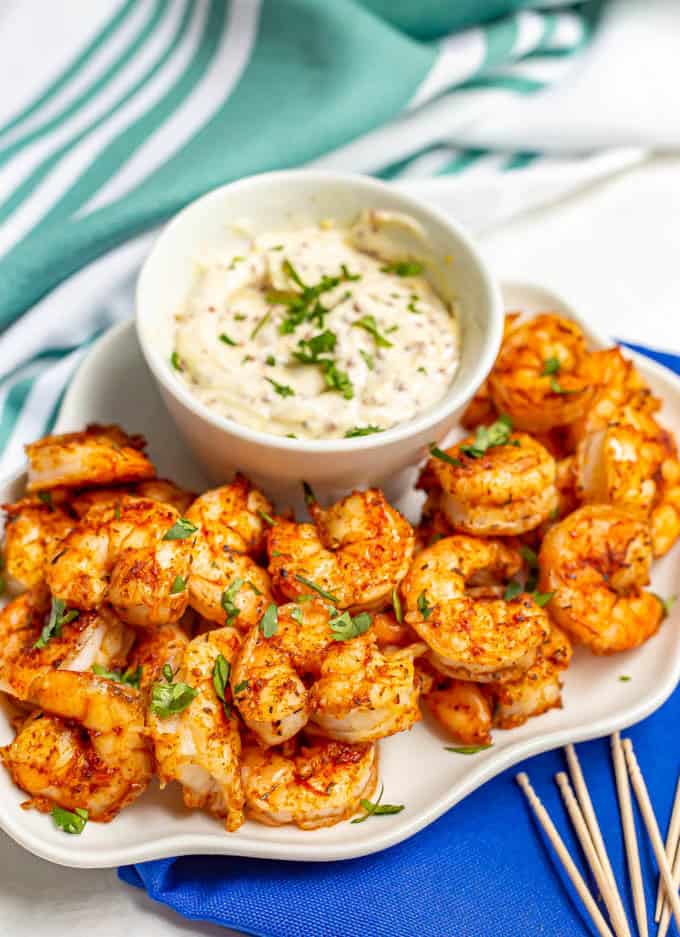 White serving tray with spicy roasted shrimp and a creamy sauce for dipping