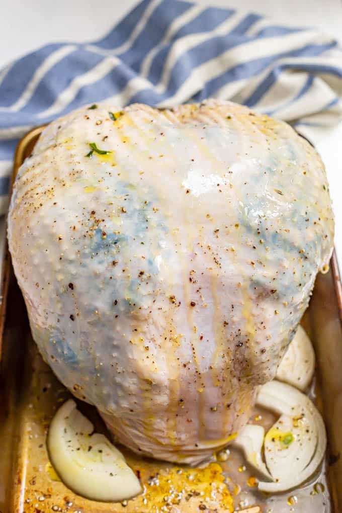 A raw turkey breast that's been stuffed with a spinach and mushroom mixture