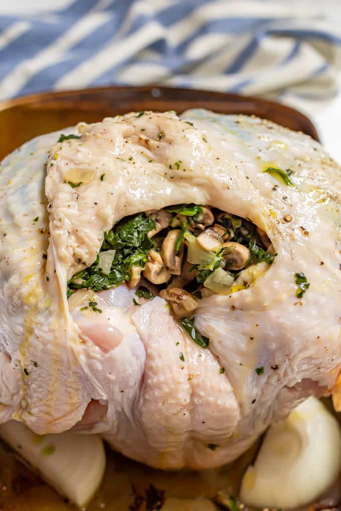 A turkey breast, before being roasted, that's been stuffed with a spinach and mushroom mixture