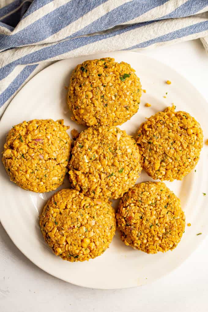 Vegetarian chickpea burger patties on a white plate before being cooked