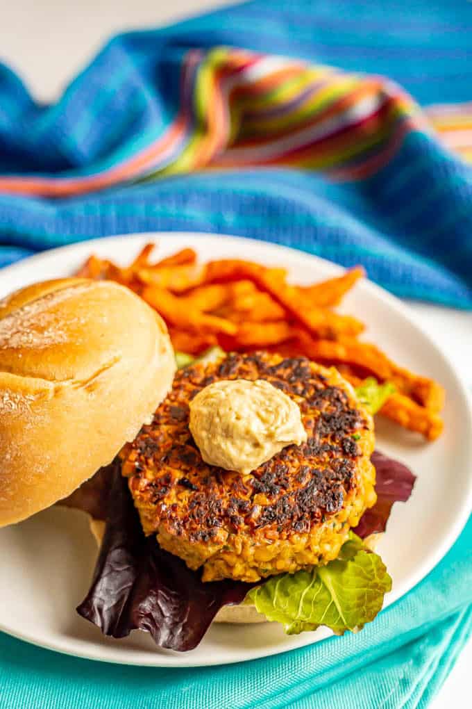 Chickpea burger served on a bun with lettuce and a dollop of hummus