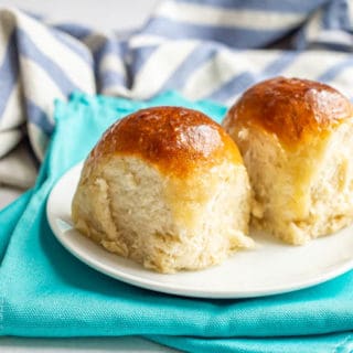 Tall fluffy dinner rolls served on a white plate