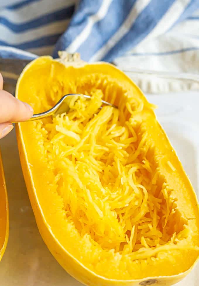 Cooked spaghetti squash with a fork pulling the strands