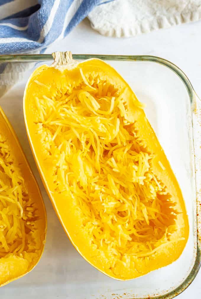 Spaghetti squash half cooked with pulled spaghetti strands