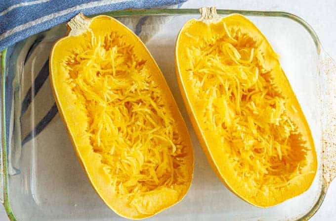 Microwave spaghetti squash halves after cooking and being pulled into strands