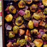 Brussels sprouts are roasted with bacon and chunks of red onion for a super flavorful veggie side dish that everyone will love! #brusselssprouts #veggiesides #sidedish #roastedveggies