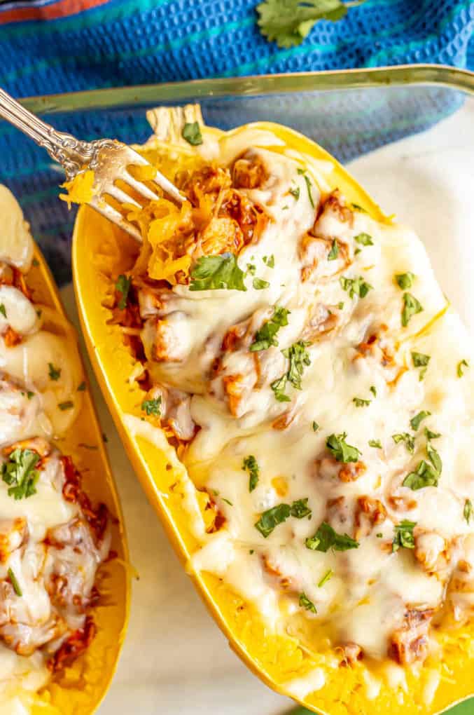 Baked spaghetti squash with chicken enchilada and melted cheese in a casserole dish