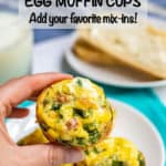 A hand holding up an egg muffin cup with spinach and cheese and a text overlay on the photo.