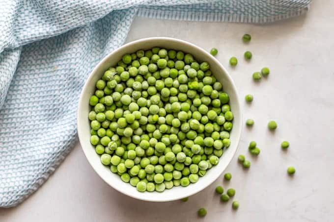 Frozen peas in a white bowl