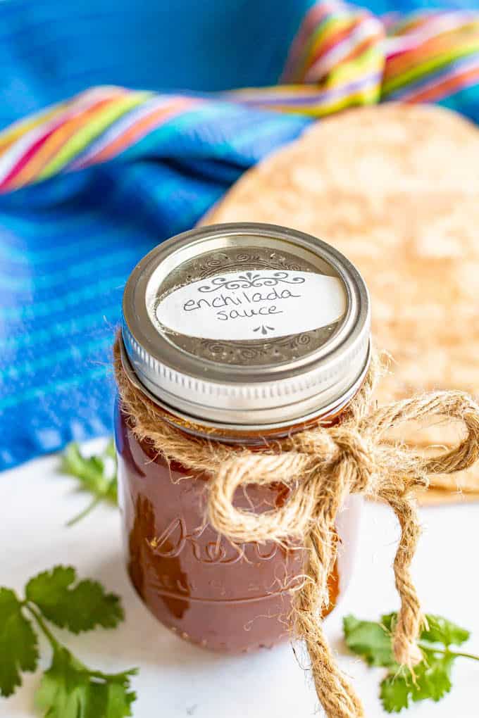 A jar of enchilada sauce with a label on top and a rope tied into a bow around it