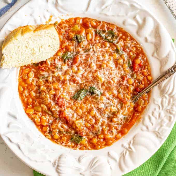 Easy lentil soup served in a white bowl with Parmesan cheese and fresh bread