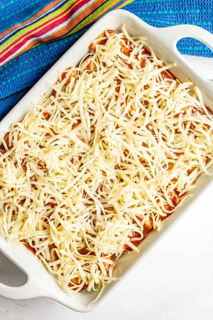 Enchilada casserole with cheese on top before being baked