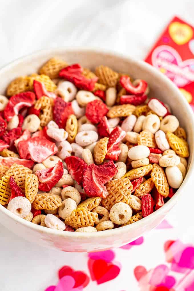 A healthy Valentine's Day snack mix with cereal, yogurt covered raisins and dried strawberries