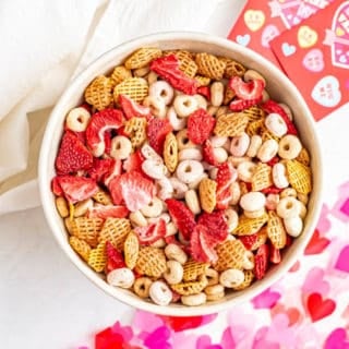 A large bowl full of toddler Valentine's Day snack mix with cereal, yogurt covered raisins and dried strawberries