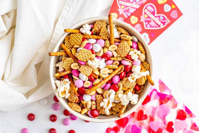 Chex mix snack with cereal, pretzels, popcorn, peanuts and Valentine's M&Ms in a bowl