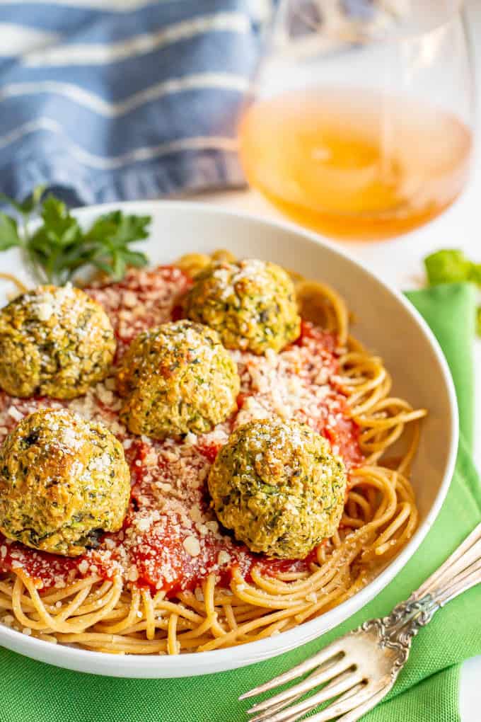 Baked veggie meatballs on top of spaghetti noodles with marinara sauce in a white bowl