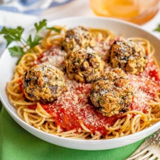 Veggie meatballs served with spaghetti and sauce in a large white bowl