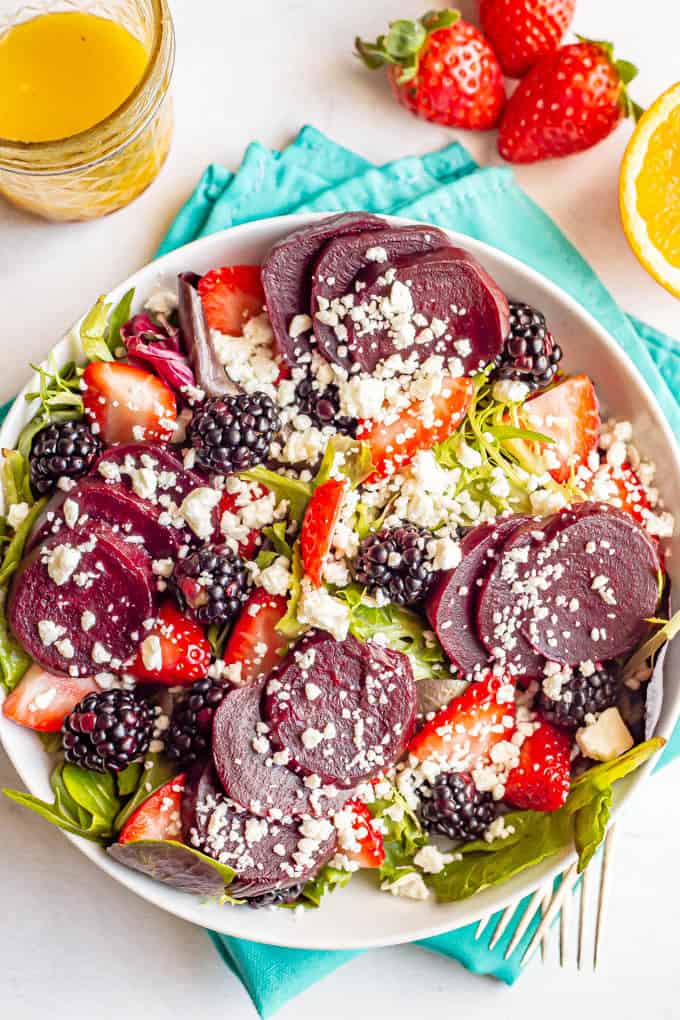 Fresh berries, roasted beets and feta cheese on a bed of spring greens