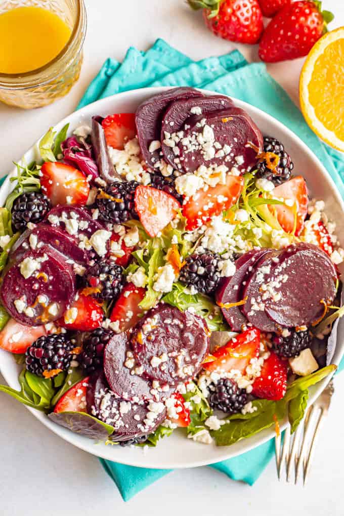 A berry beet salad served in a large bowl with feta cheese and an orange vinaigrette on top