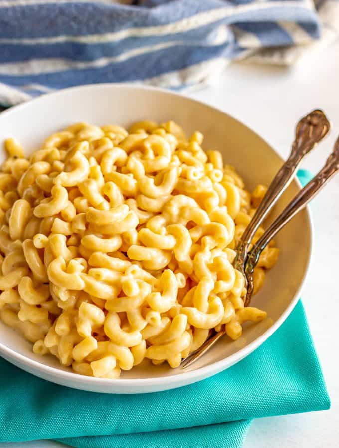 Creamy macaroni and cheese served in a bowl with two forks tucked in