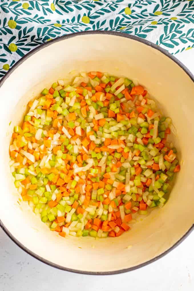 A sauteed mix of onion, carrots and celery in a large pot