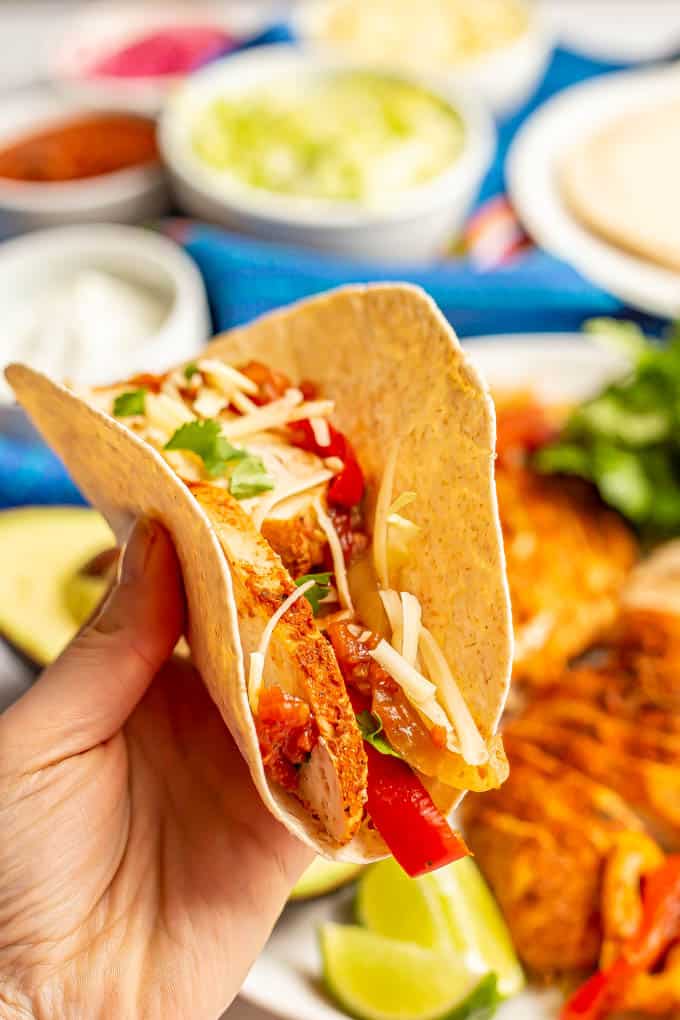 A hand holding a stuffed chicken fajita