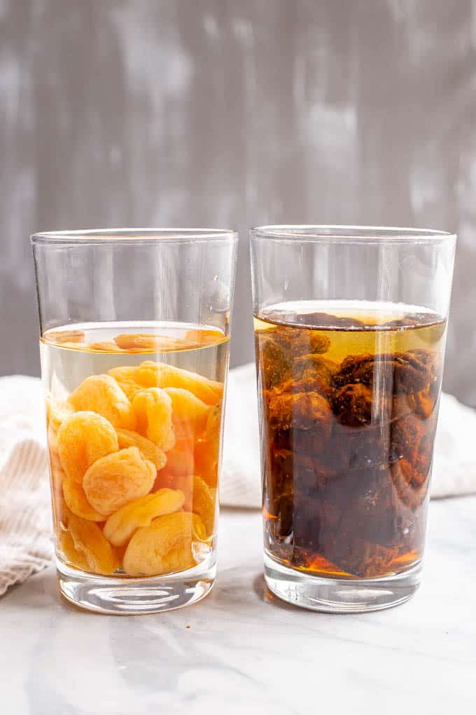 Dried apricots and prunes soaking in water in glasses