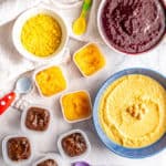 Bowls and small containers of different kinds of baby food purees