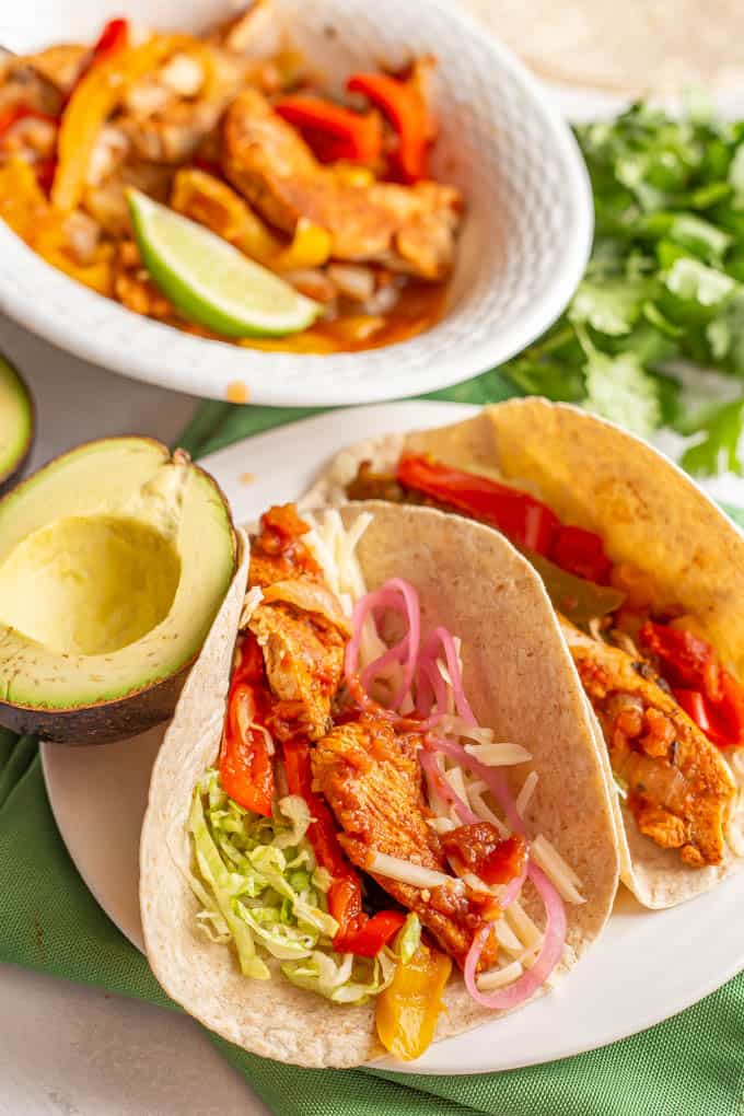 Fajitas served on a plate in flour tortillas with chicken and toppings