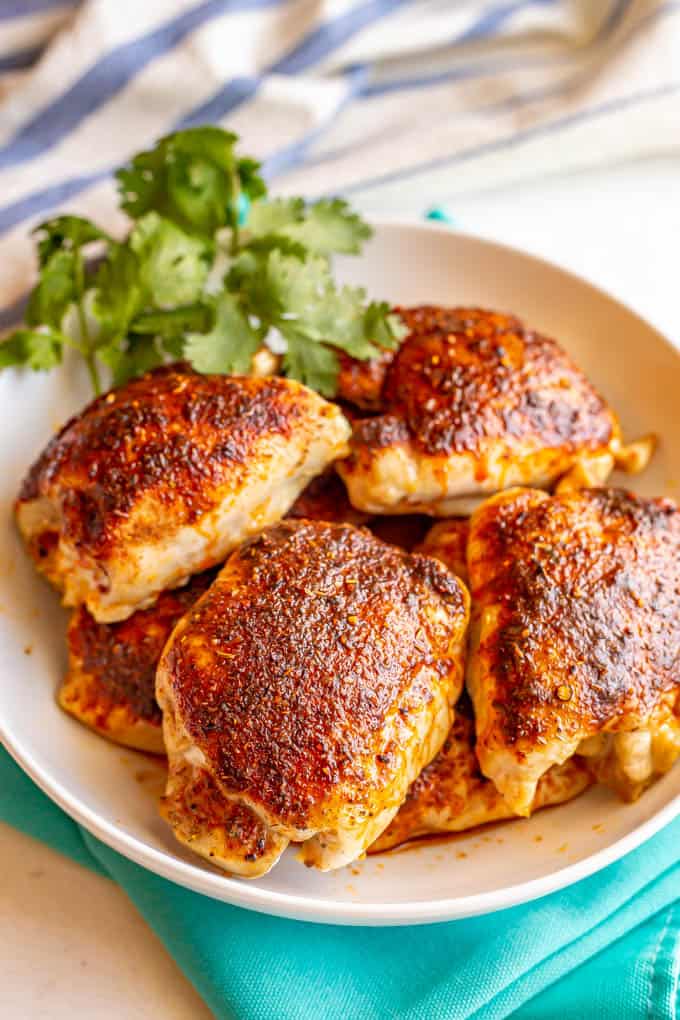 Seasoned baked chicken thighs piled in a large serving bowl
