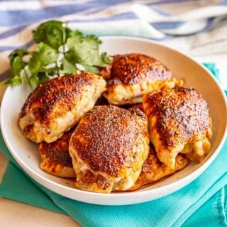 Chicken thighs ready to be served from a large white bowl