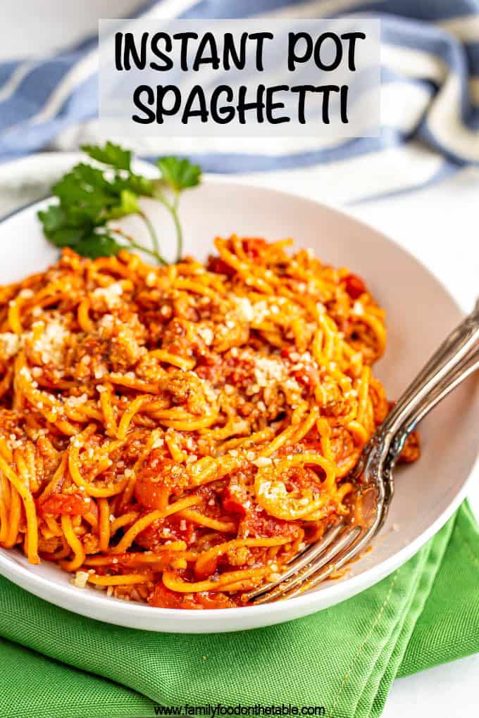 A bowl of spaghetti with two forks tucked inside and a text box on top of the photo