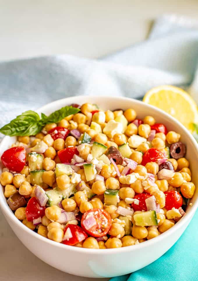 Chickpeas and veggies mixed with a dressing and served in a large bowl