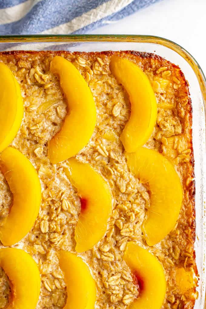 A close up of a baked oat breakfast dish with peach slices on top