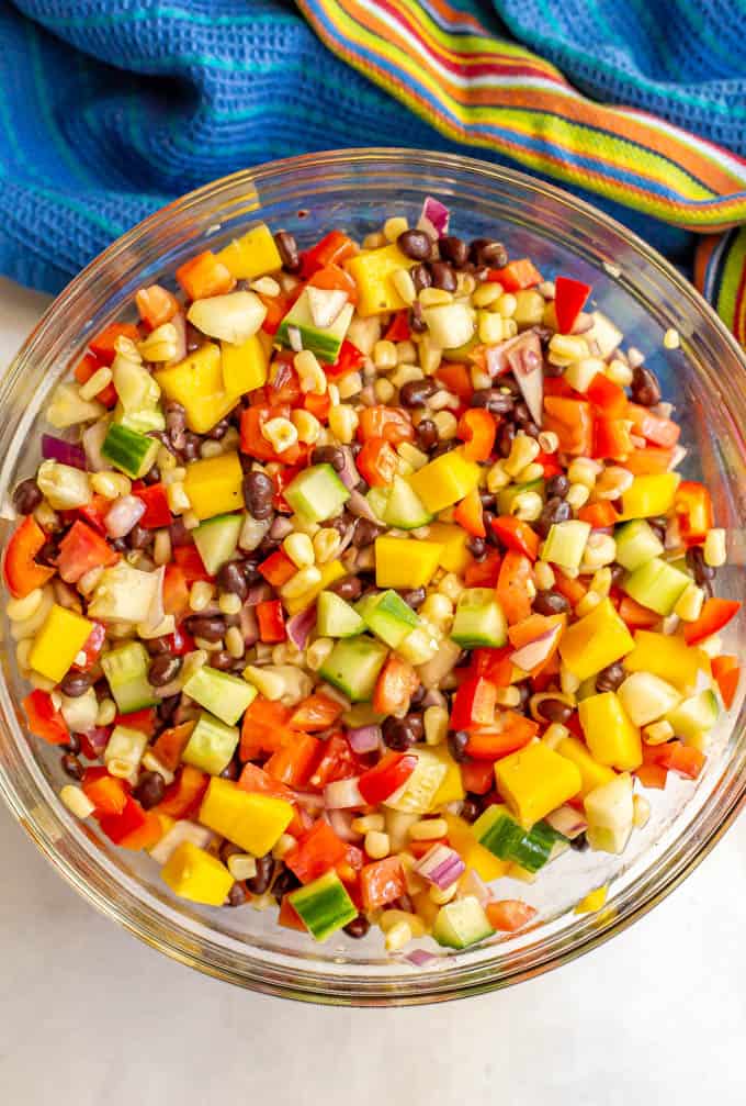 Black bean mango salad with fresh veggies served in a large clear glass bowl