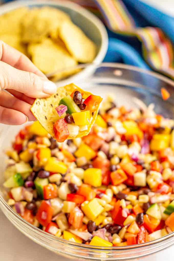 A chip scooping up a black bean and mango salsa