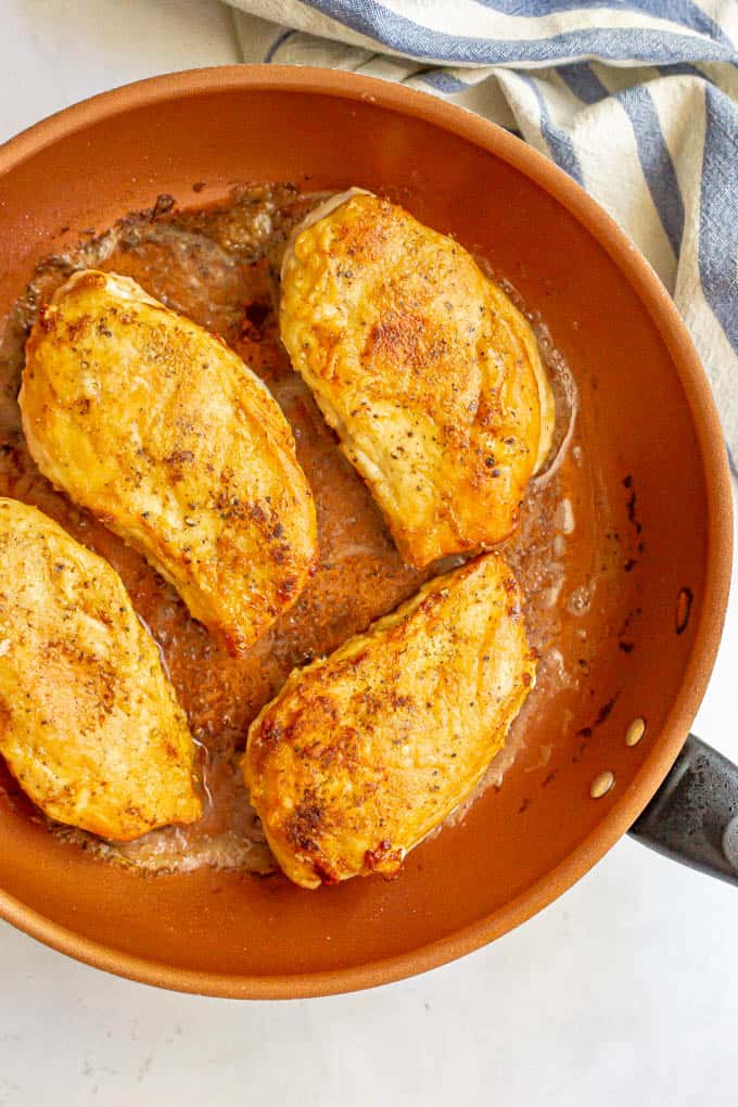 Golden brown seared chicken breasts in a large skillet