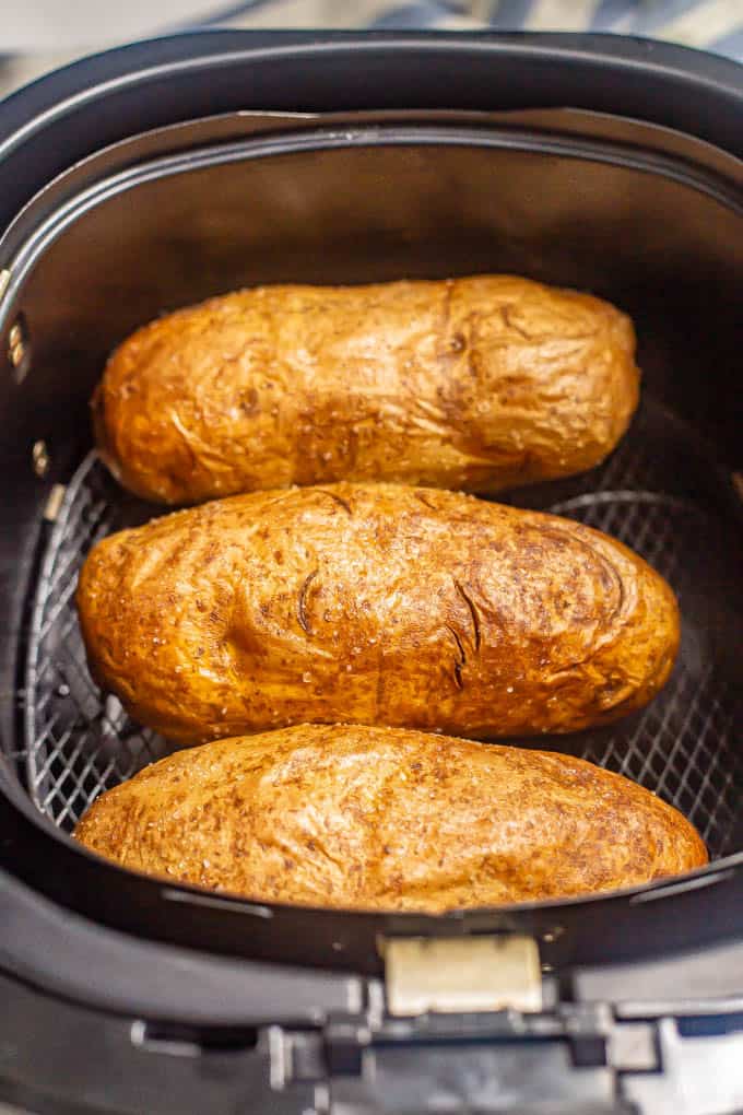 Three russet potatoes in an Air Fryer tray after cooking