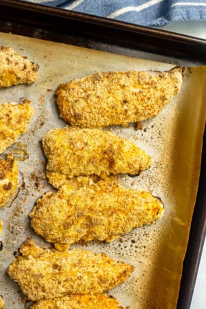 Crispy chicken tenders on a baking sheet lined with parchment paper