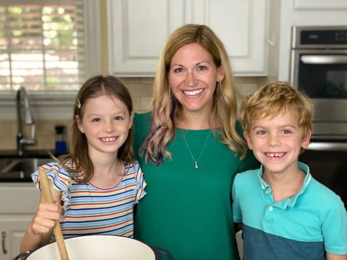 A mom and her two children cooking together in a kitchen