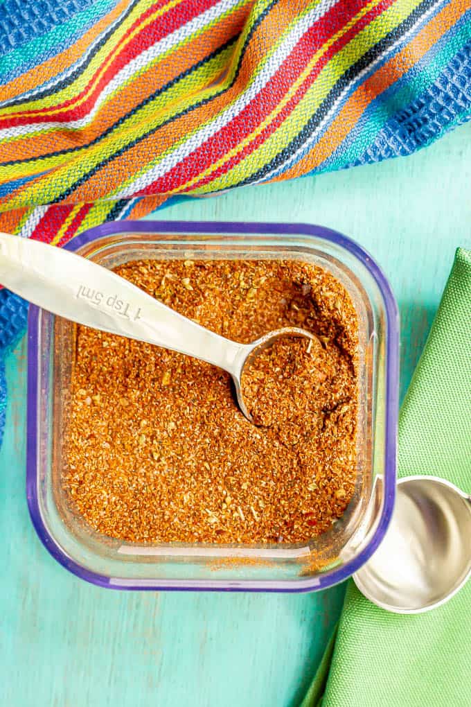 A teaspoon resting in a container of southwest seasoning