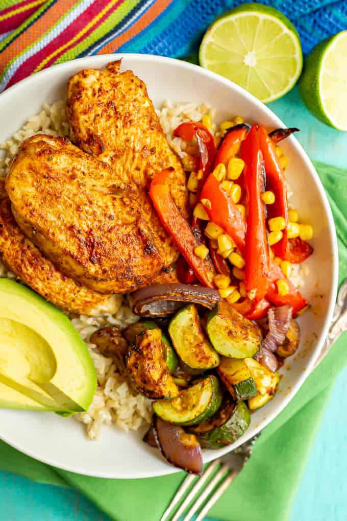 Southwest seasoned chicken and veggies served over rice in a large white bowl