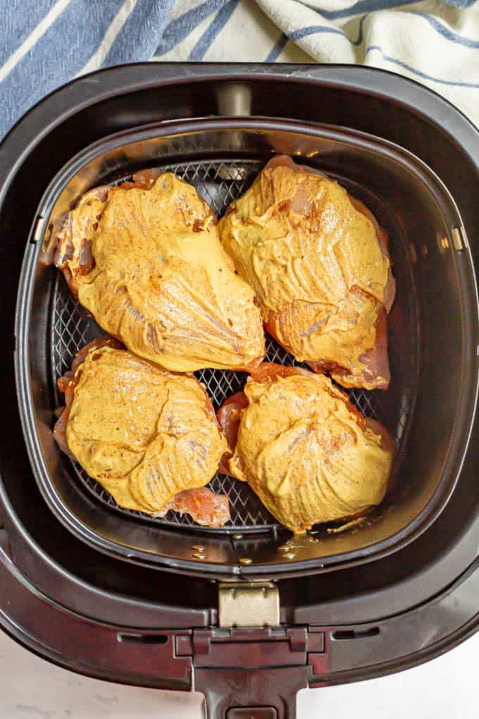 Dijon topped chicken thighs in an Air Fryer tray before cooking