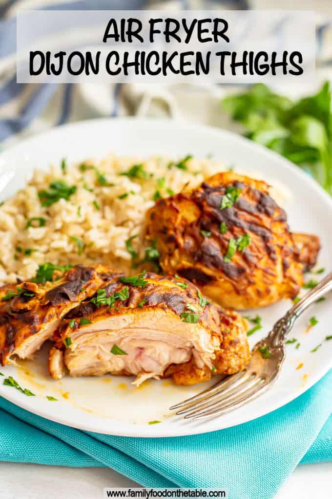 Two cooked chicken thighs with Dijon mustard served on a white plate with rice and a text box on top