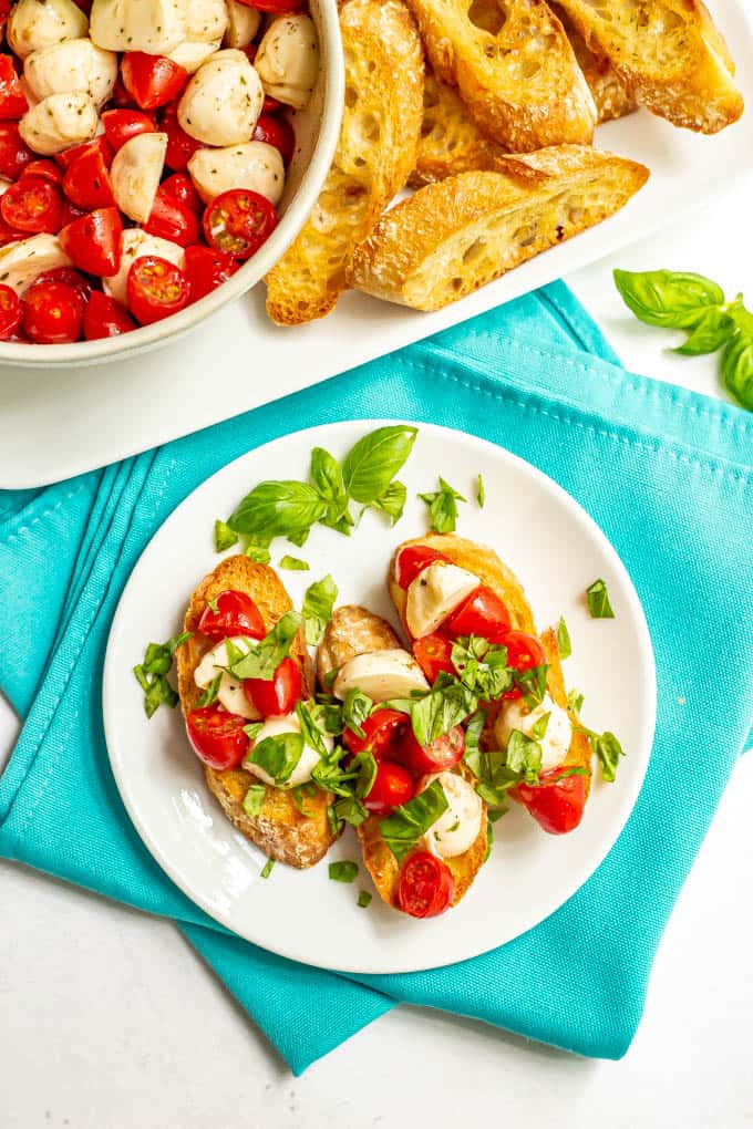 A small serving plate of bruschetta appetizer with basil sprinkled over top